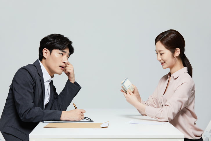 보험 증권을 꼼꼼히 살피며 전문가와 함께 사망보험금을 미리 받는 법과 종신보험 활용 방안을 상담하는 고객의 모습